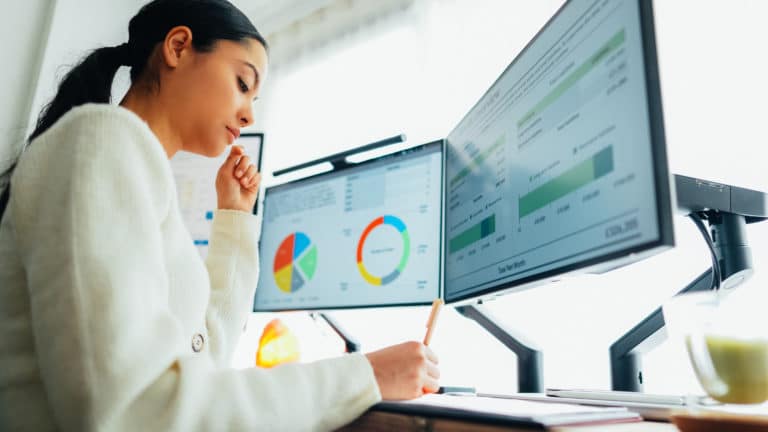 Woman analysing data on computer screens